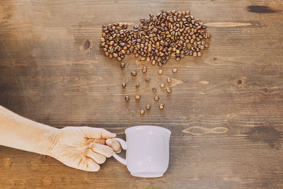 High angle view of hand holding drink on table