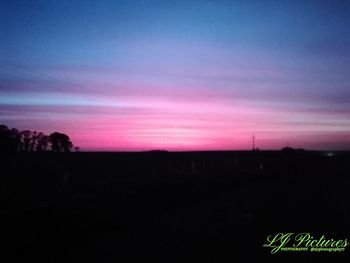 Scenic view of silhouette field against sky at sunset