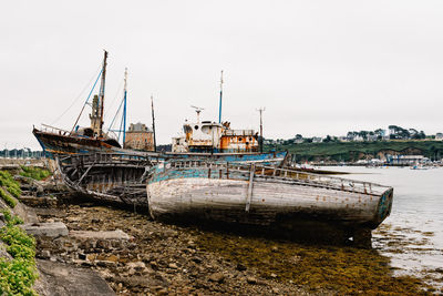 Fishing boats moored on beach against clear sky