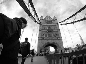 People on tower bridge against sky