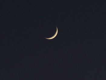 Low angle view of half moon against sky at night