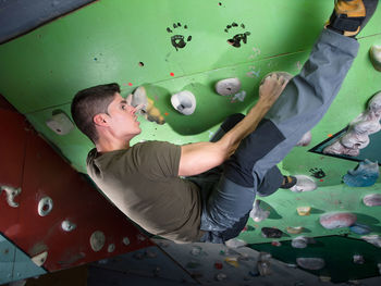 Full length of man climbing wall