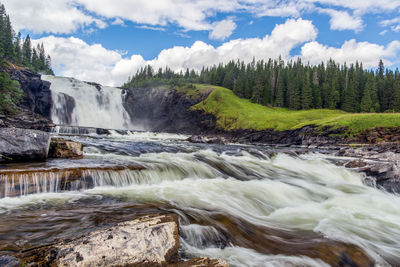 Scenic view of waterfall against sky