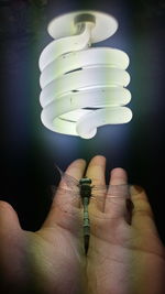 Close-up of hand holding light bulb