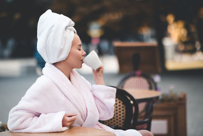 Woman wearing bathrobe drinking coffee