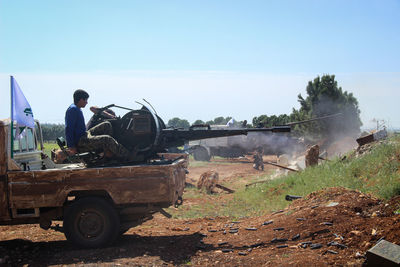 People working on field against clear sky