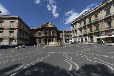 Street amidst buildings in town against sky