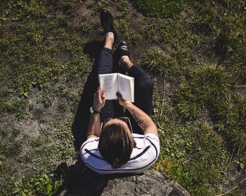 Rear view of woman sitting on book