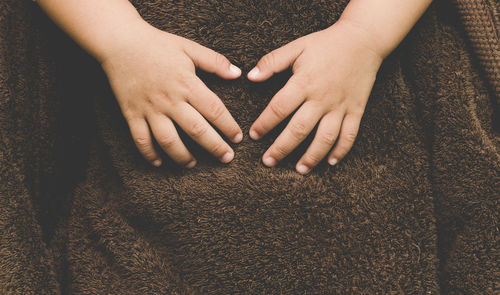 Cropped hands of child with blanket 