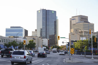 Traffic on city street and buildings against sky