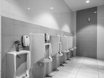 A black and white image of an empty men's restroom in public place.