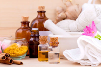 Aromatherapy products on wooden table against wall