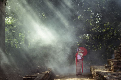Rear view of man standing in forest