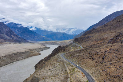 Scenic view of road by mountains against sky