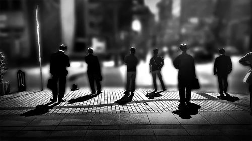 Tilt shift image of men on footpath