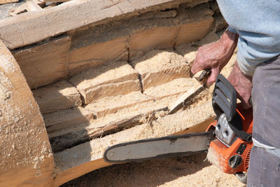 Chainsaw,close-up of woodcutter sawing chain saw in motion, sawdust fly to sides