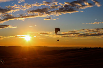 Panoramic view of the sunset over the hills with a paraglider 