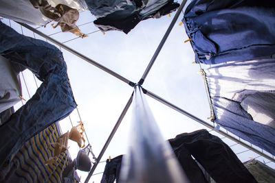 Low angle view of laundry drying on rack against sky