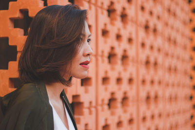 Woman looking away by wall