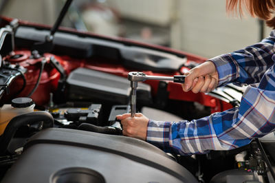 Midsection of man repairing car