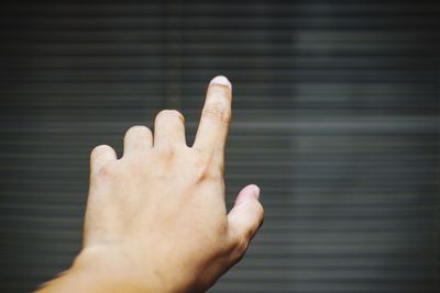 Cropped image of person hand in sea