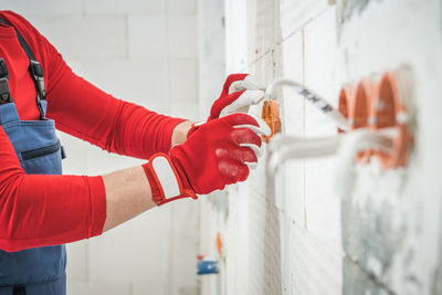 Midsection of man standing against wall