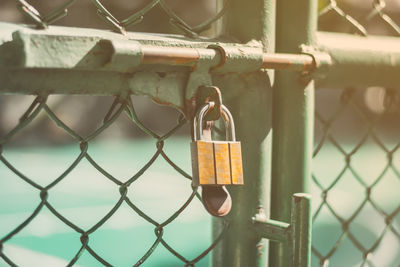 Close-up of padlock on chainlink fence