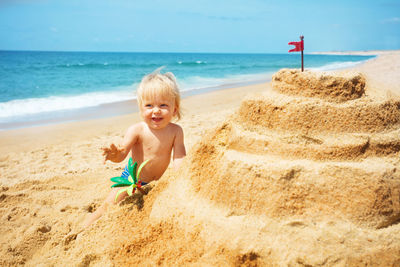 Rear view of boy playing at beach against sky