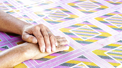 Cropped hands on patterned tiled floor