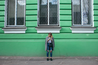 Full length of woman standing on railing