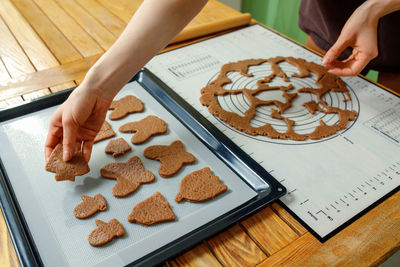 Midsection of woman preparing gingerbread cookies on table