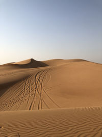 Sand dunes in desert against clear sky