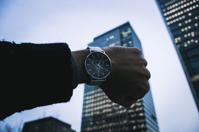 Low angle view of human hand against the sky