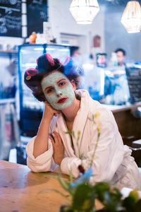 Portrait of young man wearing mask on table