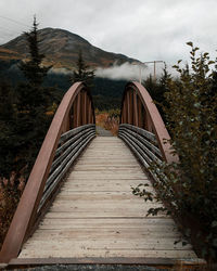 Rustic bridge on trail through foggy autumn mountains