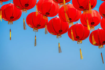 Low angle view of lanterns hanging by building against sky