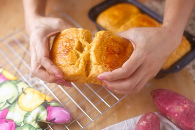 High angle view of woman holding bread on table