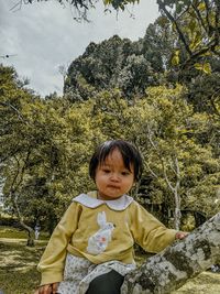 Portrait of young woman sitting on field