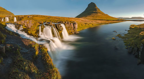 Scenic view of waterfall against sky