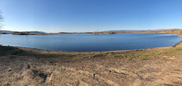 Scenic view of lake against clear blue sky