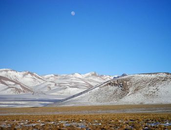 Snow covered mountains against clear blue sky