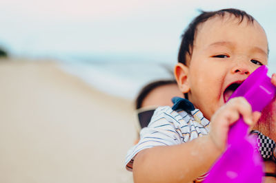 Cute boy playing on beach against sea