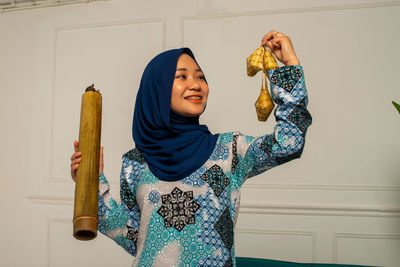 Woman standing against wall at home