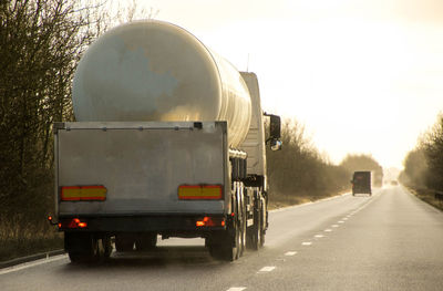 Vehicles on road in city against sky