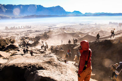 People on mountain range against sky