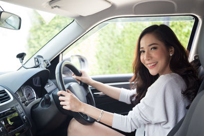 Portrait of smiling woman sitting in car