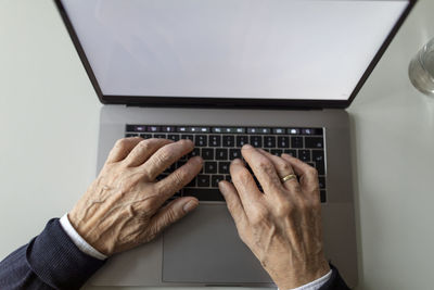 Close-up of senior man using laptop