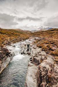 Scenic view of waterfall against sky