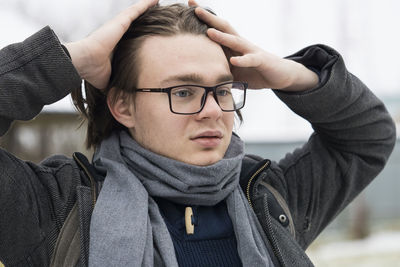 Thoughtful young man wearing warm clothing looking away