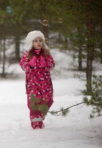 Girl walking on snow covered land